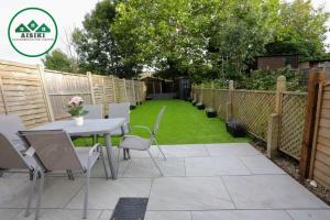 eine Terrasse mit einem Tisch und Stühlen im Hinterhof in der Unterkunft Aisiki Apartments at Stanhope Road, North Finchley, Airconditioned Multiple 2 or 3-Bedroom, Pet Friendly Duplex Flats, King or Twin Beds with Free Wi-Fi in Finchley