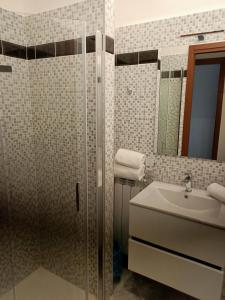 y baño con ducha, lavabo y espejo. en Appartamenti Speedy en Fiumicino