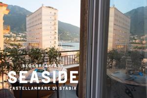 a window with a view of a city with buildings at B&B SEASIDE in Castellammare di Stabia +15 photos