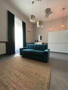 een woonkamer met een blauwe bank en een groot tapijt bij A un passo dal Castello Maschio ANGIOINO Appartment in Napels