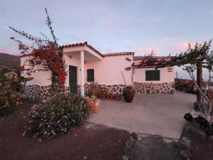 una pequeña casa blanca con un patio enfrente en Finca Arcoíris Tenerife VV, en Guía de Isora