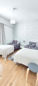 拉赫的住宿－Reissupesä，一间卧室设有两张床和蓝色凳子。