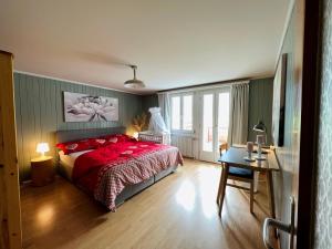 una camera da letto con un letto con cuscini rossi e un tavolo di ”Heimet” im Berner Oberland a Unterbach