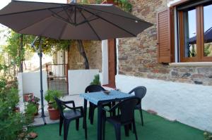 una mesa y sillas bajo una sombrilla en un patio en Il Rifugio del vecchio Bandito, en Iglesias