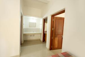 a hallway with a bathroom with a sink and a door at Daffodil Rooms - Non AC in Tellicherry