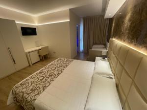 Habitación de hotel con cama grande y escritorio. en Hotel Conca Verde, en Lignano Sabbiadoro