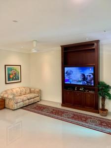 ein Wohnzimmer mit einem Sofa und einem Flachbild-TV in der Unterkunft Puncak Villa 10-20pax in Kuala Kangsar