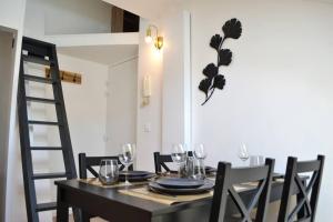 a dining room with a table with chairs and wine glasses at Le Cocon Filaterie in Annecy