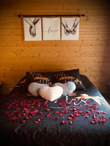 deux animaux farcis pondant sur un lit avec des roses sur celui-ci dans l'établissement Une Pause Douceur - Suite All in Wood, à Eyguières