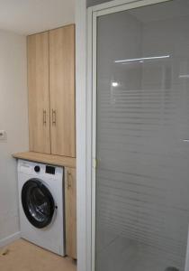a laundry room with a washing machine and a glass door at Le Cocon Filaterie in Annecy