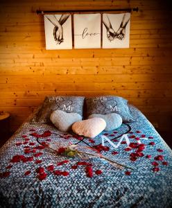 - une chambre avec un lit orné de fleurs rouges dans l'établissement Une Pause Douceur - Suite All in Wood, à Eyguières