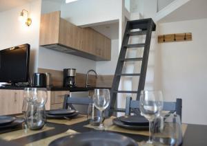 a kitchen with a table with wine glasses on it at Le Cocon Filaterie in Annecy