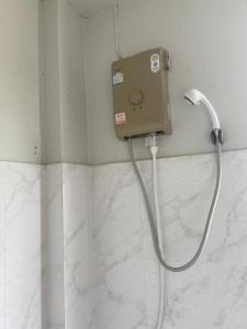 a shower in a bathroom with a hose attached to the wall at The Sandy House Khaolak in Khao Lak