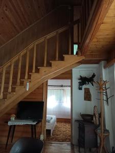 una sala de estar con una escalera de madera en una casa en Domek w Gorcach, 