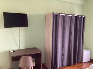 Zimmer mit einem lila Duschvorhang und einem Schreibtisch in der Unterkunft B&B Verdi in Lecce