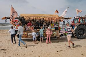 贊德沃特的住宿－B&B de Drukkerij Zandvoort - luxury private guesthouse，一群人站在海滩上的食物车周围