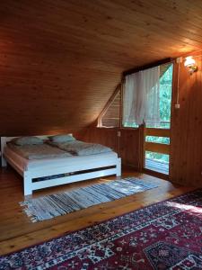 Dormitorio con cama y ventana en una cabaña en Domek w Gorcach, 