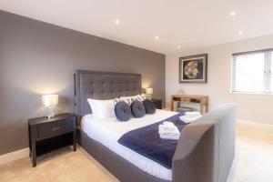 ein Schlafzimmer mit einem großen Bett mit blauen Kissen in der Unterkunft Ketley Vallens in Telford