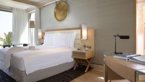 a bedroom with a bed and a desk with a laptop at Jumeirah Muscat Bay Oman in Muscat