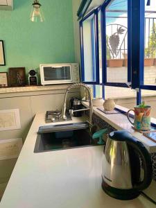 fregadero de cocina con tetera en la encimera en Passiflora Suite en Safed