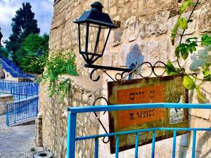 ein Straßenlicht an der Seite einer Steinmauer in der Unterkunft Passiflora Suite in Safed
