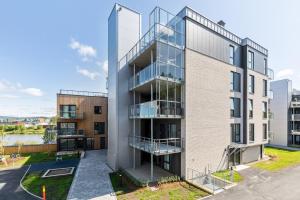 ein Mehrfamilienhaus mit Glasfassade in der Unterkunft Clean and Modern - 25 Min to Oslo City & OSL in Lillestrøm