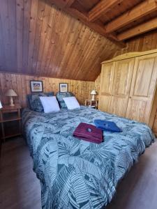 ein Schlafzimmer mit einem Bett in einer Holzhütte in der Unterkunft Chalet 6 pers avec piscine in Cabourg