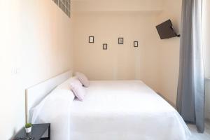 a white bedroom with a white bed and a window at Grazioso Appartamento Trastevere in Rome