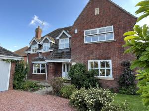 a red brick house with white windows at Stunning 5 bedroom country home with amazing views in Leamington Spa