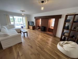 sala de estar con sofá blanco y chimenea en Stunning 5 bedroom country home with amazing views, en Leamington Spa