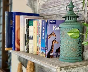 a book shelf with books and a thermos at Salama House - your peaceful, poolside retreat in Watamu