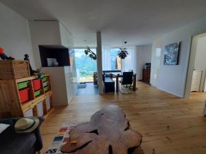 salon z drewnianą podłogą i stołem w obiekcie Panorama * w mieście Obstalden
