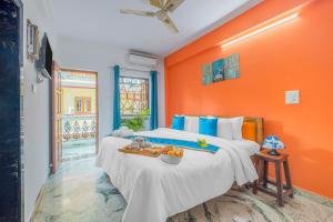 um quarto com uma cama grande e uma parede laranja em The Sequeira Goa em Majorda