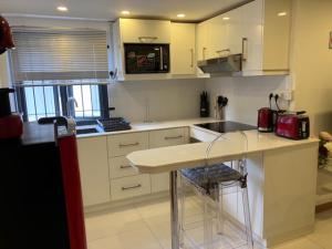 una cucina con armadi bianchi e piano di lavoro di Seaview Terrace Appartement a Flic-en-Flac