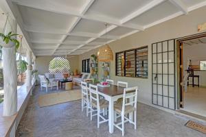 uma sala de jantar e sala de estar com mesa e cadeiras em Salama House - your peaceful, poolside retreat em Watamu