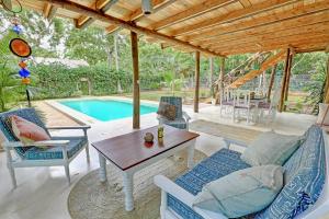 um pátio com uma mesa e cadeiras e uma piscina em Salama House - your peaceful, poolside retreat em Watamu