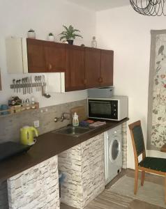 a kitchen with a sink and a microwave at Pitypang lak in Szigetmonostor