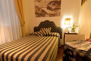 a bedroom with a bed with a striped comforter at Florence Room B&B in Florence