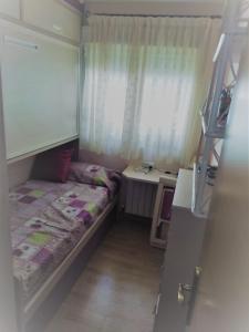 niewielka sypialnia z łóżkiem i biurkiem w obiekcie ALQUILER DE HABITACIÓN w Madrycie