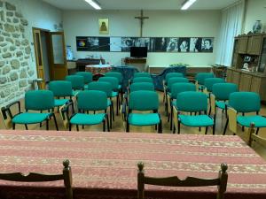 una habitación con hileras de sillas y una mesa en Stabat Mater Casa di Preghiera en Valdragone