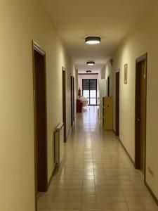 un couloir d'une chambre avec un long couloir dans l'établissement Stabat Mater Casa di Preghiera, à Valdragone