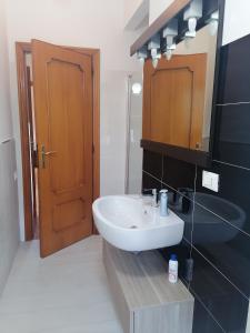 bagno con lavandino bianco e specchio di B&b Villaggio Sole a Sulmona