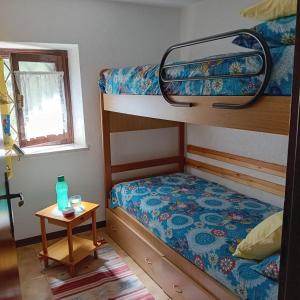 a bedroom with two bunk beds and a table at Haus Granata Family - Trekking - Bike in Giazza