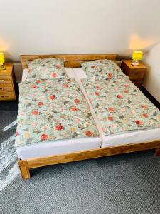 a bedroom with a bed with a floral bedspread at Hotel Pension Schienfatt am Dornumersieler Tief in Dornum