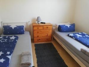 two twin beds in a room with a dresser at Apartment White, Wohnung in Altenstadt