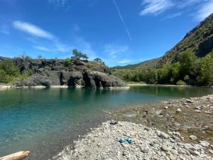 un cuerpo de agua con una orilla rocosa con montañas en el fondo en Villa Giorgia en Borgo Val di Taro