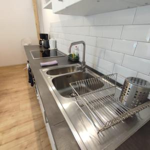 un lavandino in acciaio inossidabile in una cucina con piastrelle bianche di Traditional Apartments Salzburg a Salisburgo