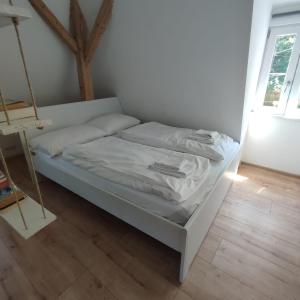 un letto con lenzuola e cuscini bianchi in una stanza di Traditional Apartments Salzburg a Salisburgo
