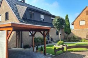 a house with a wooden pavilion in front of it at Ferienwohnung Waldrand am See 