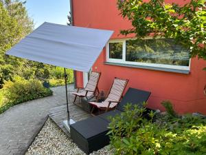 ein weißer Regenschirm und zwei Stühle auf einer Terrasse in der Unterkunft Homequartier Passau in Passau